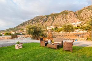 a group of chairs and a table in the grass at Kelly's Sunset Apartment 2 Kalamata in Almirón