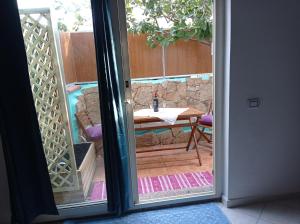 una porta che conduce a un patio con tavolo all'aperto di exclusive house sardinia a Cala Gonone