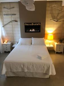 - une chambre avec un grand lit blanc et une cheminée dans l'établissement ZEROstuni suite apartment, à Ostuni