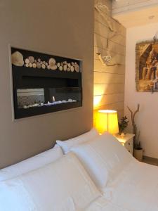 Un dormitorio con una cama blanca con una foto en la pared en ZEROstuni suite apartment en Ostuni