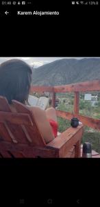 a woman sitting on a bench reading a book at ECOCABAÑAS CERRO ARKO in Mendoza