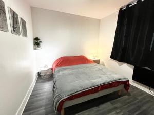 een slaapkamer met een bed met een rode deken bij Appartement de charme T2 au coeur de Bourges in Bourges