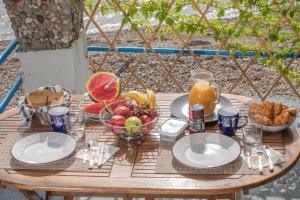 - Mesa con desayuno de fruta, pan y zumo de naranja en Agistri By The Sea en Perama