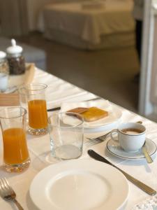 a table with plates of food and glasses of orange juice at ZEROstuni suite apartment in Ostuni