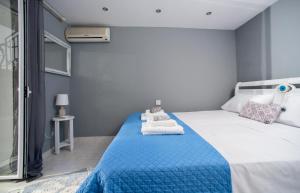 Un dormitorio con una cama azul y blanca con toallas. en Agistri By The Sea en Perama
