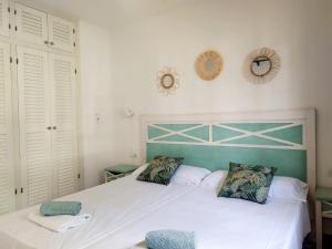 ein Schlafzimmer mit einem weißen Bett mit einem grünen Kopfteil in der Unterkunft Cheap & Chic Apartamentos en Son Bou de 2 dormitorios in Son Bou