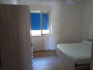 um pequeno quarto com uma cama e uma janela em Case Vacanze De Simone zona Pozzillo em Castellabate
