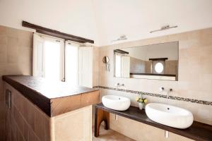 een badkamer met 2 wastafels en een grote spiegel bij Il Melograno in San Leonardello
