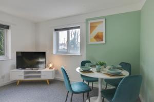 sala de estar con mesa, sillas y TV en Central Chelmsford - Two Bed flat with Parking - Free Wifi and Netflix en Chelmsford