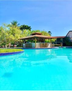 a large blue swimming pool with a gazebo at Angá Beach Hotel in São Miguel dos Milagres