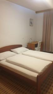 a bedroom with two beds and a desk with a desk at Hotel Knez in Kupres