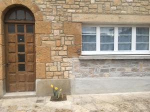 - un bâtiment avec une porte, une fenêtre et des fleurs dans l'établissement Les studios de Philibert, à Figeac