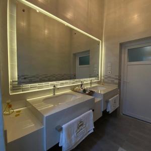 uma casa de banho com 2 lavatórios e um espelho grande em The Palace Chalet em Salalah