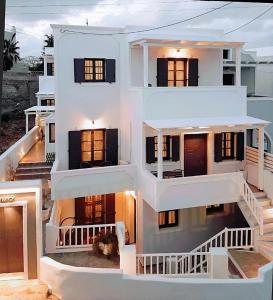 a large white house with a dog sitting in front of it at Lefteris Houses in Karterados