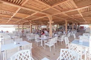 a restaurant with white tables and chairs and a wooden ceiling at Orange Palace Side - All Inclusive in Side