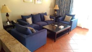 a living room with blue couches and a coffee table at Patio suite, Porto marina in El Alamein