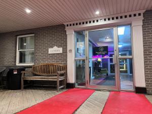 un tapis rouge devant un bâtiment avec un banc dans l'établissement Harbourview Inn and Suites, à Sydney