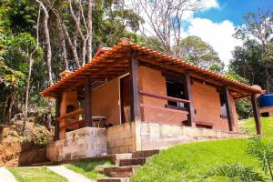a small brick house on a hill with trees at Chale com lazer completo em Lima Duarte MG in Conceição da Ibitipoca
