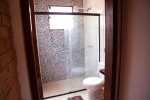 a bathroom with a glass shower with a toilet at Chale com lazer completo em Lima Duarte MG in Conceição da Ibitipoca