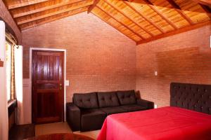 a living room with a couch and a red table at Chale com lazer completo em Lima Duarte MG in Conceição da Ibitipoca