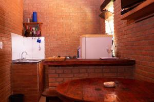 a kitchen with a wooden table and a refrigerator at Chale com lazer completo em Lima Duarte MG in Conceição da Ibitipoca