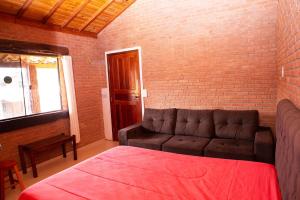 a living room with a couch and a brick wall at Chale com lazer completo em Lima Duarte MG in Conceição da Ibitipoca
