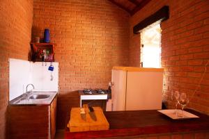 a kitchen with a counter with a refrigerator and a sink at Chale com lazer completo em Lima Duarte MG in Conceição da Ibitipoca