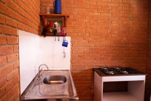 a kitchen with a sink and a brick wall at Chale com lazer completo em Lima Duarte MG in Conceição da Ibitipoca