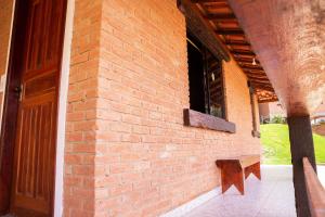 a brick wall with a window and a bench at Chale com lazer completo em Lima Duarte MG in Conceição da Ibitipoca