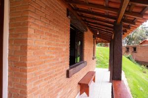 a brick building with a bench next to a window at Chale com lazer completo em Lima Duarte MG in Conceição da Ibitipoca