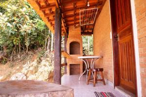 a patio with a table and chairs and a brick oven at Chale com lazer completo em Lima Duarte MG in Conceição da Ibitipoca