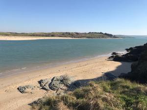 a beach with some rocks and the water at Harbour Retreat Padstow - Entire Apartment in Padstow