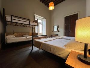 a bedroom with two bunk beds and a lamp at Iturbide500 hostal in San Luis Potosí