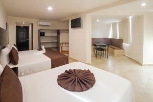 a hotel room with two beds and a table at Mayev Express in Santa Cruz Huatulco