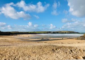 a group of people on a beach near the water at Harbour Retreat Padstow - Entire Apartment in the beautiful old town of Padstow Harbour in Padstow