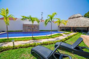 a resort with a swimming pool and palm trees at Mayev Express in Santa Cruz Huatulco