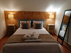 een slaapkamer met een bed met 2 lampen en een spiegel bij Espaço Roteiro de Mimos in São Vicente Ferreira +47 foto's