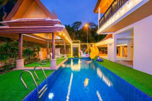 a swimming pool with a slide in a house at Bali Beach Pool Villa in Pattaya South
