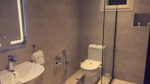 a bathroom with a toilet and a sink at Voyage Apartments فوياج للشقق المخدومة in Riyadh