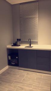 a kitchen with a sink and a counter with a window at Voyage Apartments in Riyadh