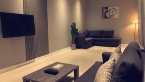 a living room with a couch and a table at Voyage Apartments فوياج للشقق المخدومة in Riyadh