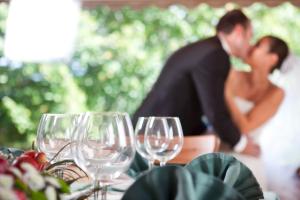 a bride and groom kissing at a table with wine glasses at Casa Grande la Almuiña in Arbo