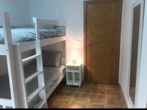 a small room with a bunk bed and a door at Apartamentos turísticos CHUS 2 in Corcubión +7 photos