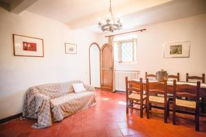 a living room with a table and a bed and a table and chairs at Agriturismo Collosodo in Monticchiello