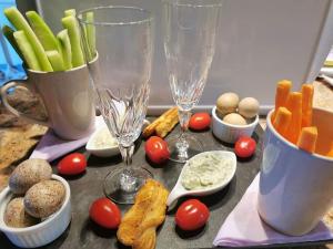 a table with wine glasses and vegetables on it at La Cabane Insolite in Puy-du-Fou
