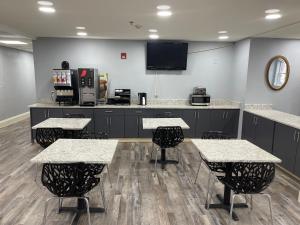 a room with tables and chairs and a counter at Super 8 by Wyndham San Antonio Downtown NE in San Antonio