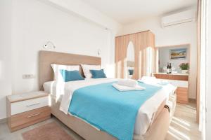 a white bedroom with a large bed with blue sheets at Villa Ines in Budva