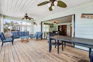 a porch with a table and chairs and a ceiling fan at The Flip Side by Meyer Vacation Rentals in Gulf Shores