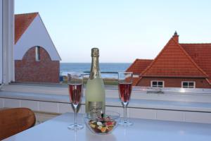 a bottle of wine and two glasses on a table at Ferienwohnung Ostseeglück, Schönberger Strand, Meerblick in Stakendorfer Strand