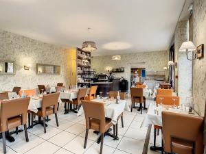 a restaurant with tables and chairs in a room at Logis Hotel Beaudon in Pierrefonds